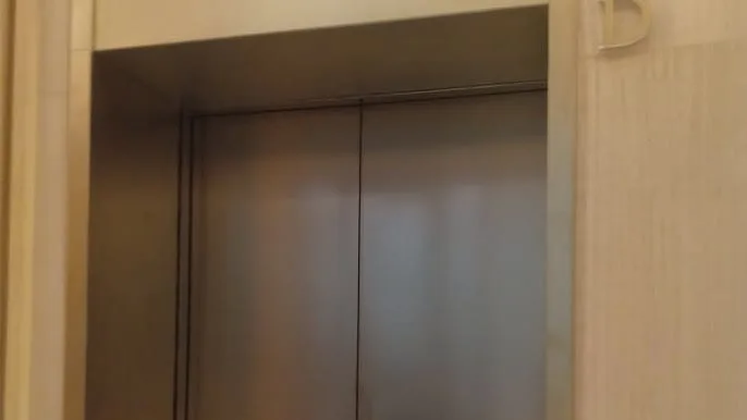 Technician performing commercial elevator scratch removal and metal panel refinishing in Honolulu